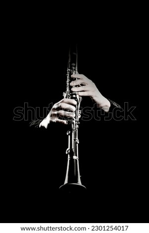 Clarinet player. Clarinetist hands playing woodwind instrument isolated on black. Musical instruments closeup