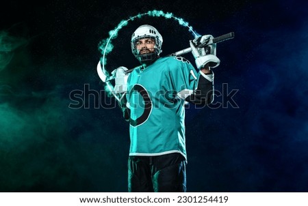 Ice hockey player. Download high resolution photo for sports betting advertisement. Icehockey athlete in the helmet and gloves on stadium with stick. Action shot. Sport concept. Sports wallpaper.