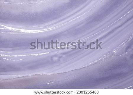 Liquid cosmetic gel or vaseline smudge texture on light purple background