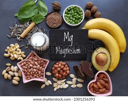 Magnesium rich foods. Natural food sources of magnesium. Assortment of fresh fruit, vegetable, nuts and seeds high in magnesium. Banana, nuts, seeds, beans, avocado, milk, dark chocolate, spinach... Royalty-Free Stock Photo #2301256393