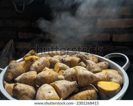 Potatoes with their skins in a stainless steel pot. ripe yam, visible smoke. healthy cooking concept, copy space, selected focus, narrow depth of field