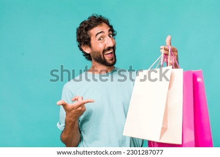 young adult hispanic crazy man. shopping bags concept