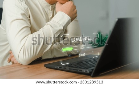 Businessman using a laptop computer for download and update software and waiting to loading digital file data form website, very slow internet form wifi. Concept of waiting for load of loading symbol. Royalty-Free Stock Photo #2301289513