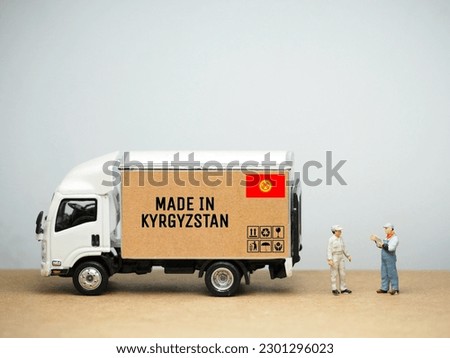 Mini toy at table with white background. Industrial shipping concept. Made in Kyrgystan design.