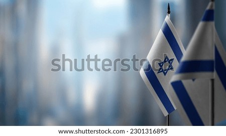 Small flags of the Israel on an abstract blurry background.