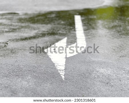 Right turn arrow drawn on asphalt_from the front_rain