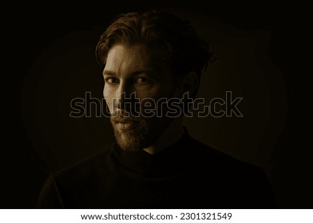 Art portrait in a dark key of a handsome forty-year-old man with curly hair, dressed in a black pullover, who looks directly and thoughtfully into the camera. People, emotions. Psychological picture. 