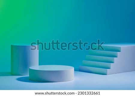 Two round cylinder podium and small stairway arranged on blue background. Abstract background with minimalist style for product brand presentation, copy space