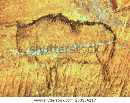 Abstract children art in sandstone cave. Black carbon paint of bison on sandstone wall, copy of prehistoric picture. 