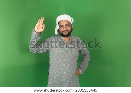 Young Indian farmer okay symbol right hand side with smiling and looking at camera, isolated on green background, green screen, copy space