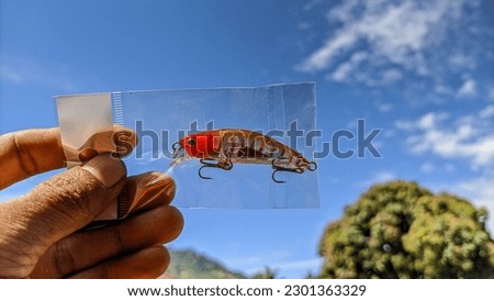 Replica minnow lure. plastic fish bait. sky background Royalty-Free Stock Photo #2301363329
