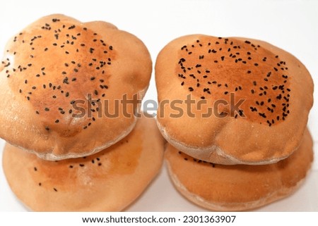Egyptian Mahlab bread, puff thin, crispy and delicious with black seed baraka seeds on top, made of flour, dry yeast, milk, eggs, sugar, salt, black seeds, warm water, with anything or on its own Royalty-Free Stock Photo #2301363907