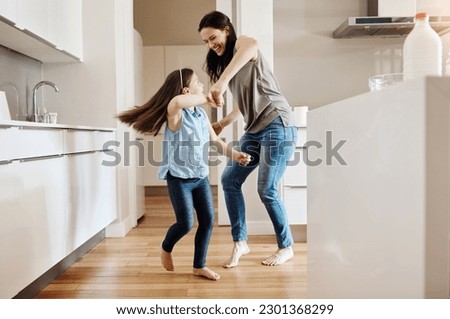 Happy, dance and a child with a mother in the kitchen, bonding and quality time together. Smile, laughing and a mom teaching her daughter with dancing, love and happiness with fun in a house