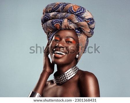 Head scarf, black woman laugh and portrait with African beauty and makeup in a studio. Isolated, grey background and traditional fashion with a female model pride with culture cosmetics and jewelry Royalty-Free Stock Photo #2301368431