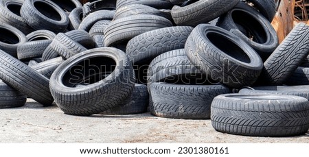Industrial dump for the processing of used tires and rubber tires. Pile of old tires and wheels for rubber recycling. Tire dump. Recycling of used tires. Produced reclaimed tire rubber Royalty-Free Stock Photo #2301380161