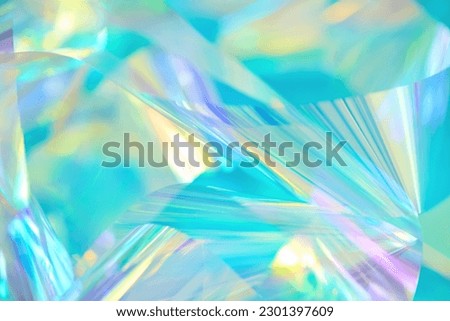 Close-up of ethereal pastel neon mint, turquoise, blue, purple holographic metallic foil background. Abstract modern curved soft focused, blurred, surreal futuristic disco, rave, dreamlike backdrop