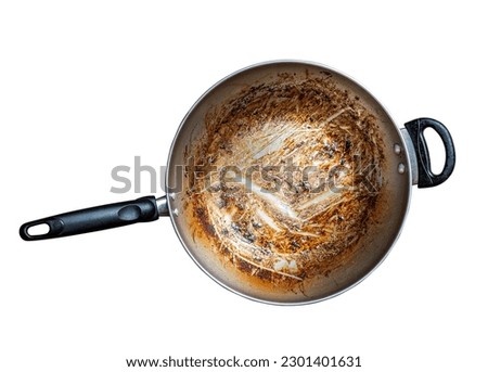 Top view of iron frying pan with burning mark, oily stains after cooking. Ingrain burning on iron pan, black handle, big area of oily stains, burnt black blemish. Isolated image on white background. Royalty-Free Stock Photo #2301401631