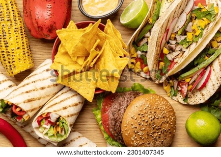 Mexican food featuring tacos, burritos, nachos, burgers and more. Flat lay closeup