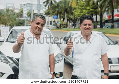 portrait of latin couple of taxi drivers men with car on background at city street in Mexico in Latin America, Hispanic people Royalty-Free Stock Photo #2301407921
