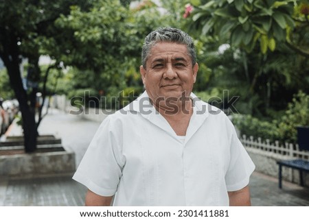 latin senior man portrait looking at camera outdoors in the street in Mexico city, hispanic adult people Royalty-Free Stock Photo #2301411881