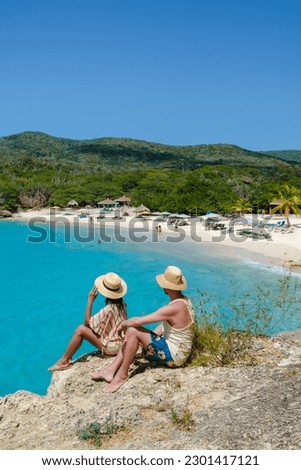 Grote Knip Beach Curacao Island, a Tropical beach on the Caribbean island of Curacao Caribbean. A couple of men and a woman on vacation in Curacao  Royalty-Free Stock Photo #2301417121