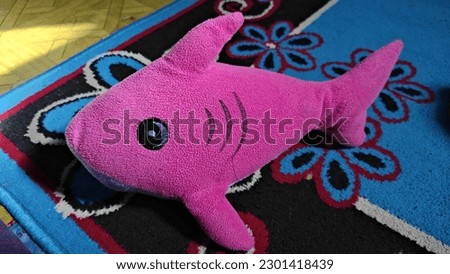 pink shark toy on the rug
