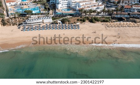 Aerial photo of the beautiful town in Albufeira in Portugal showing the Praia da Oura golden sandy beach, with hotels and apartment in the town, taken on a summers day in the summer time. 