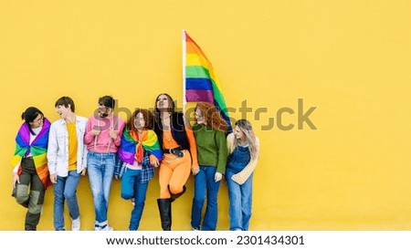 Young group of people leaning on yellow background celebrating together LGBTQI gay pride festival day. LGBT young friends having fun together outdoors. Youth homosexual community concept. Copy space. Royalty-Free Stock Photo #2301434301