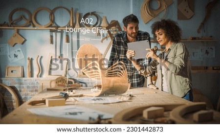 Multiethnic Female Furniture Designer is Showing Professional Male Carpenter New Chair Design On Tablet Computer. VFX 3D Hologram Edit Appears on the Work Table With Measurements for Production.