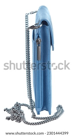 Modern miniature summer handbag-purse made of genuine leather of pale blue color, on a chain, the view from the end, highlighted on a white background.