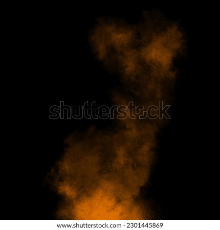 Orange color powder explosion isolated on black background. Royalty high-quality free stock photo image Freeze motion orange powder exploding. Colorful dust explode. Paint Holi, dust particles splash
