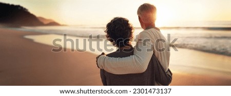 A happy senior couple enjoys their golden years, watching a breathtaking beach sunset together. Embodying the essence of retirement and relaxation, they share quality time and savor the good life. Royalty-Free Stock Photo #2301473137
