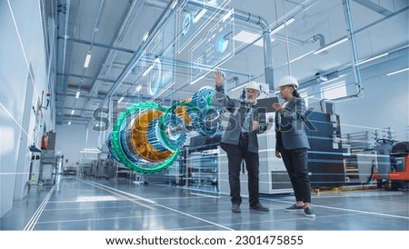 Factory Digitalization: Two Industrial Engineers Use a Tablet Computer, Visualize 3D Model of Clean Green Energy Engine. Industry 4 High-Tech Electronics Facility with Machinery Manufacturing Products