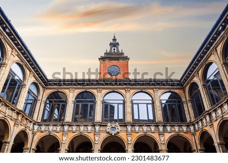 Bologna, Italy Biblioteca Comunale dell'Archiginnasio courtyard with clock tower against sky. Royalty-Free Stock Photo #2301483677