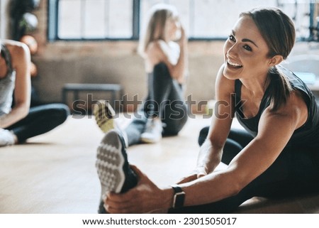 Fitness, gym and women stretching, exercise and workout goal for wellness, balance and stress relief. Female people, girls and athletes on the floor, stretch legs and smile with training and health Royalty-Free Stock Photo #2301505017