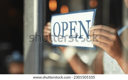 Open sign, restaurant window and hands of person, small business owner or manager with cafe door poster for welcome. Retail sales waitress, coffee shop barista and closeup board for store service
