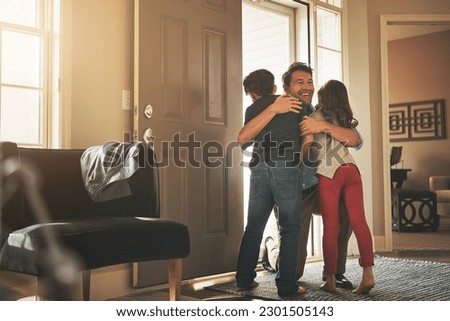 Home, love and a father hugging his kids after arriving through the front door after work during the day. Greeting, family or children with a man holding his son and daughter in the living room Royalty-Free Stock Photo #2301505143