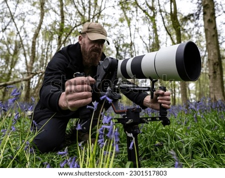 A photographer with a huge camera, lens and gimbal in the outdoors