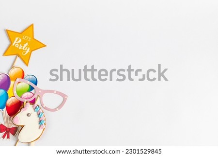 bright multicolored party accessories, star, balloons, toy unicorn head gingerbread and carnival mask on white background with empty space for text