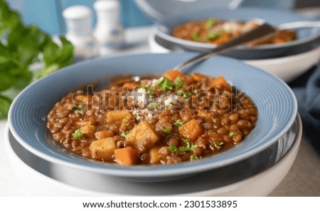 Lentil stew with tomatoes, celery, carrots, herbs and bacon. Topped with parmesan cheese. Italian cuisine Royalty-Free Stock Photo #2301533895