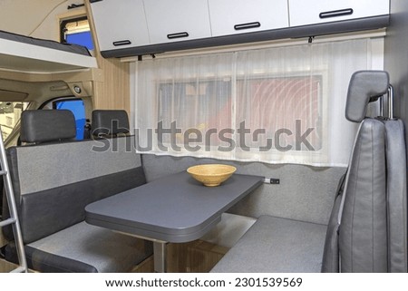 Four Seats Seating Area in Camper Recreational Vehicle Grey Interior Royalty-Free Stock Photo #2301539569