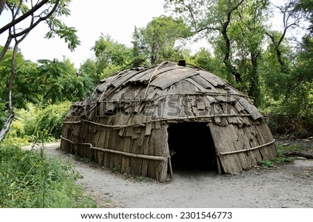 A fully constructed replica of a Wetu, or a domed shaped hut that were the homes for the people of the Wampanoag tribe.  Royalty-Free Stock Photo #2301546773