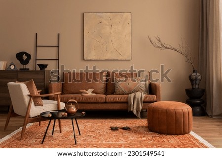 Stylish composition of living room interior with mock up poster frame, brown sofa, boucle armchair, round pouf, wooden sideboard, slippers and personal accessories. Home decor. Template.
