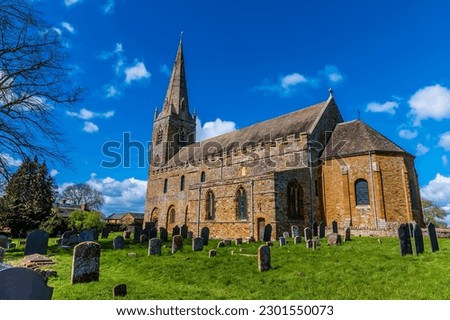 A view across the sunlit side of the Anglo Saxon church in the village of Brixworth, Northamptonshire, UK in summertime Royalty-Free Stock Photo #2301550073