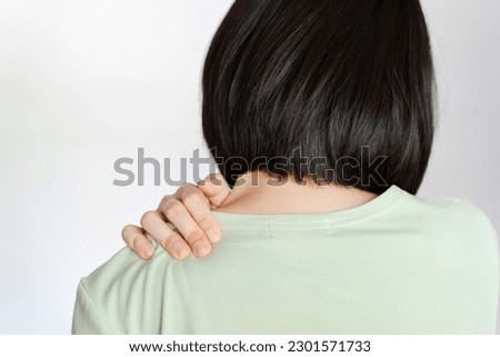 Women suffer from shoulder blade pain after sitting for a long time until they suffer from office syndrome. Royalty-Free Stock Photo #2301571733
