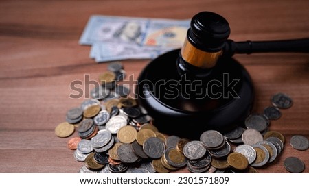 The gavel on a dollar bill in a courtroom represents the complex interplay between alimony law, alimony taxes, financial power, highlighting the need for clear legal frameworks, ethical considerations Royalty-Free Stock Photo #2301571809