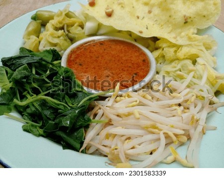 Pecel. In the form of several vegetables such as spinach, bean sprouts, cucumber, turi flowers and chicory mixed with peanut sauce. Boiled vegetables are placed on a plate. Indonesian food.