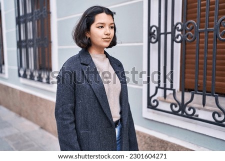 Young woman looking to the side with relaxed expression at street