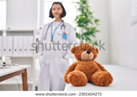 Young woman wearing doctor uniform standing at clinic