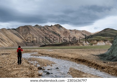 If you look back on the way to the mountain tops of the Landmannalaugar valley in Iceland, you could see the rainbow colors of the mountain chain on the other side. Royalty-Free Stock Photo #2301636797